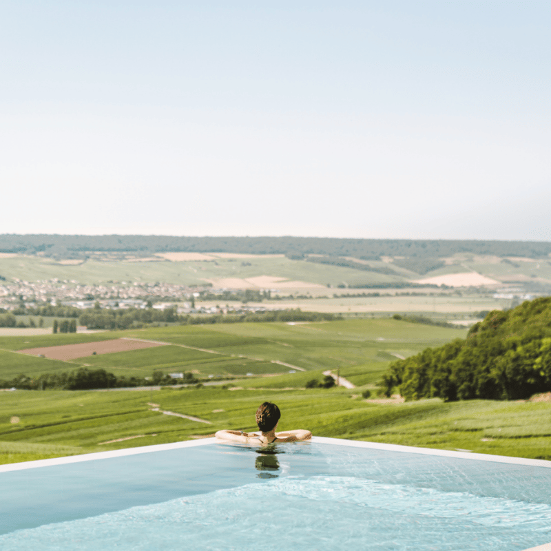 Piscine extérieure avec vue sur les vignes de Champagne.